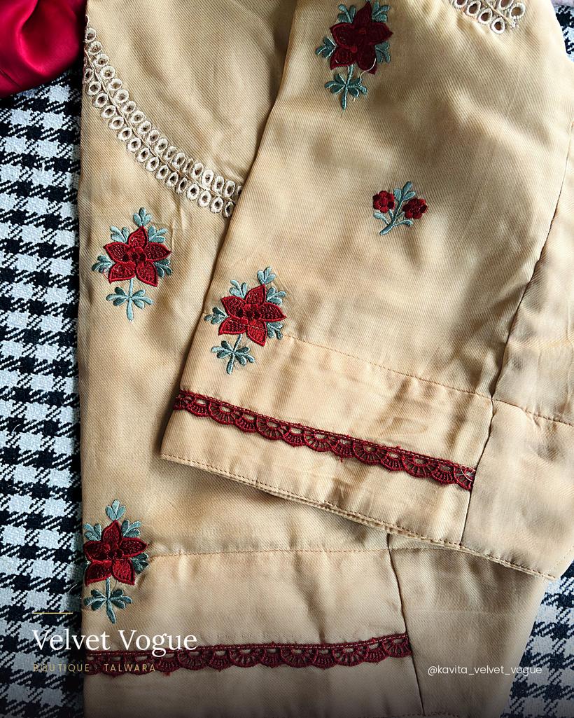 Beige and maroon embroidery, with a lace border along the sleeve.